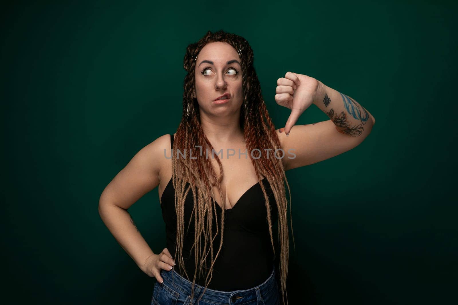 A woman with dreadlocks is contorting her facial muscles, displaying a variety of expressions. She appears to be expressing a range of emotions through her gestures and playful grimaces.