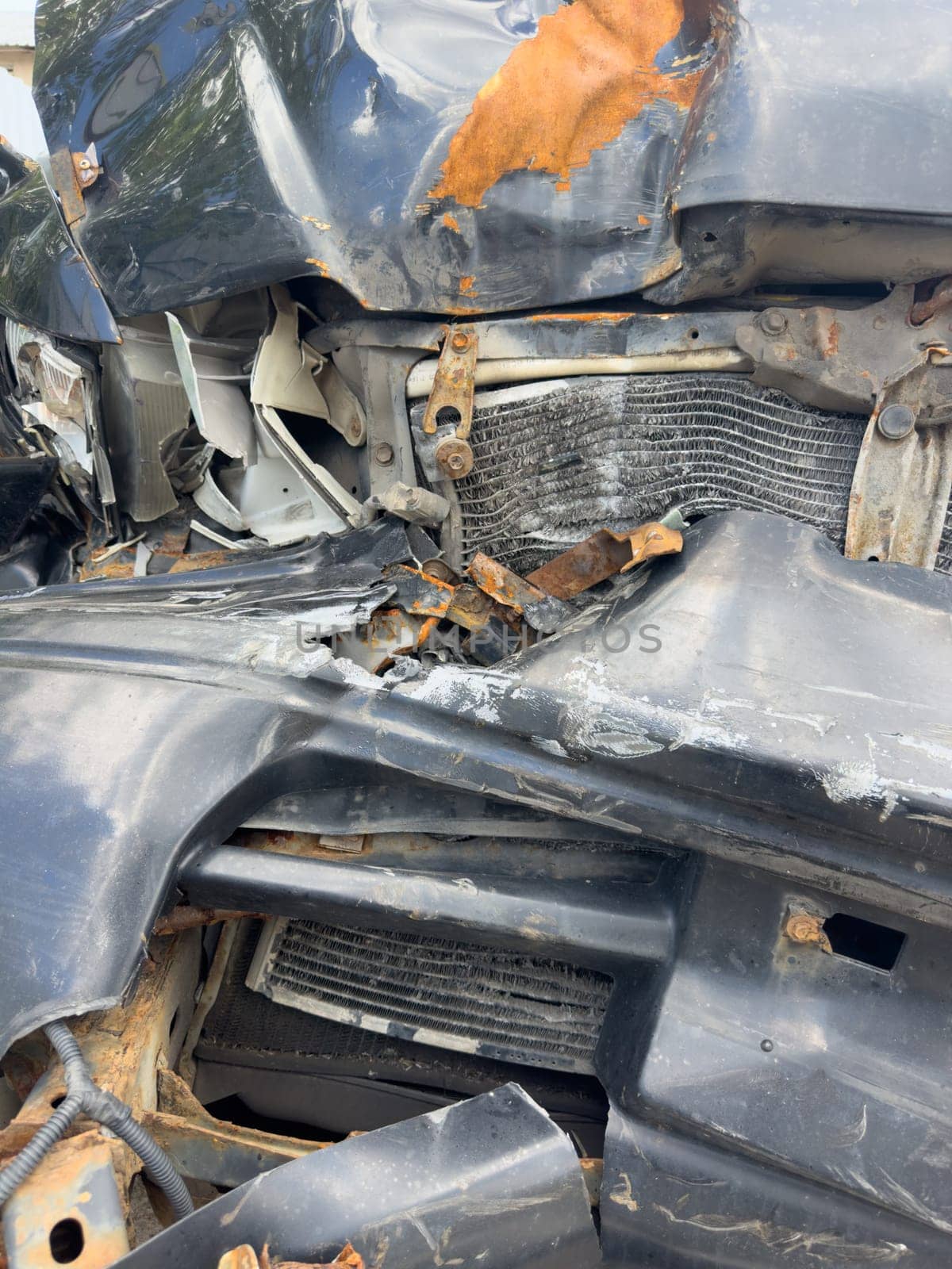 broken passenger car with rust close-up, standing outside, crumpled metal, broken headlight