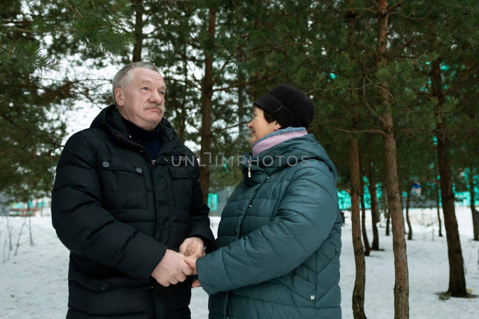 European mature family having fun walking through the winter forest.
