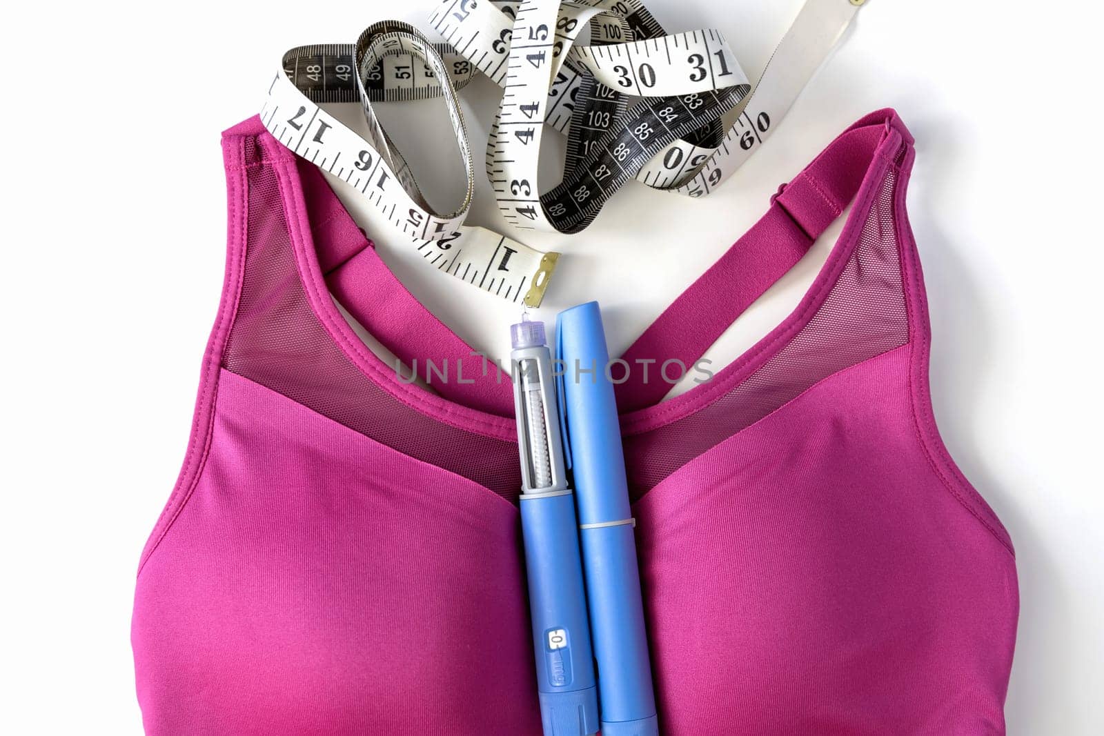 Concept of losing weight with the diabetes drug Ozempic. Layout with sports top and Ozempic syringe pen. High quality photo