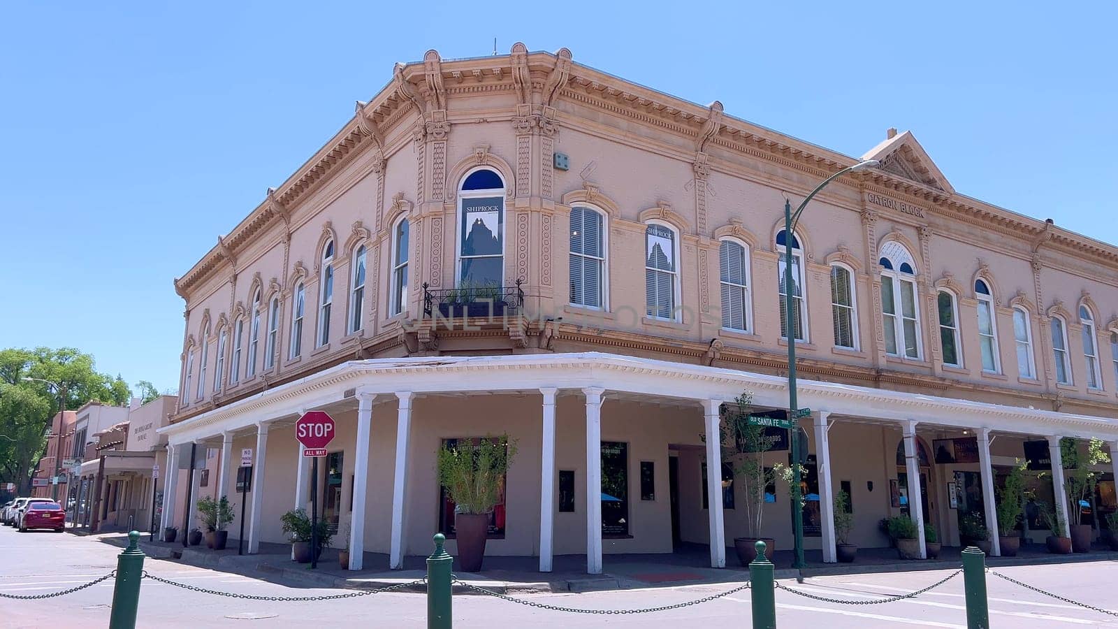 Santa Fe, New Mexico, USA-June 11, 2024-Slow motion-The main square of a historic downtown area featuring traditional adobe buildings, lively shops, and pedestrians enjoying a sunny day.