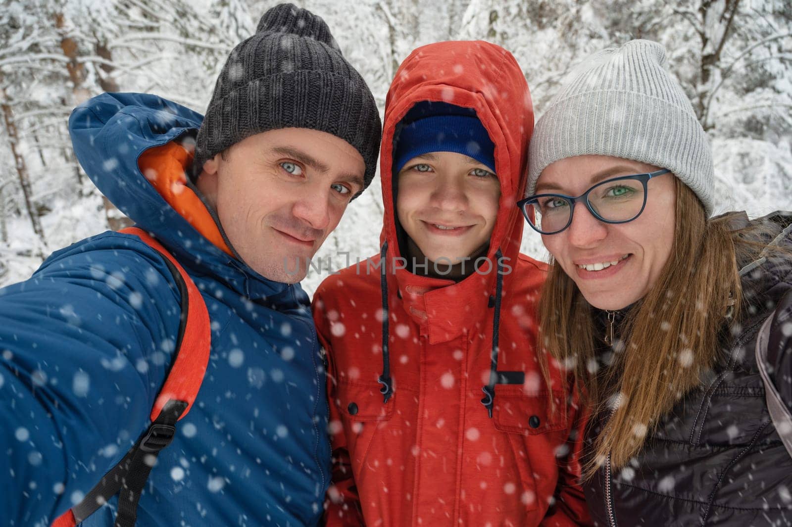 Happy family with walking in snowy winter forest, selfie photo