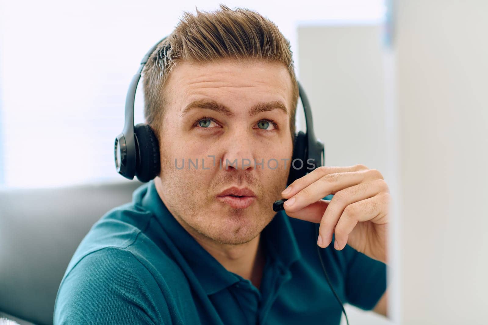 A detailed close-up captures a focused customer support representative wearing a headset while providing assistance in a call center setting.