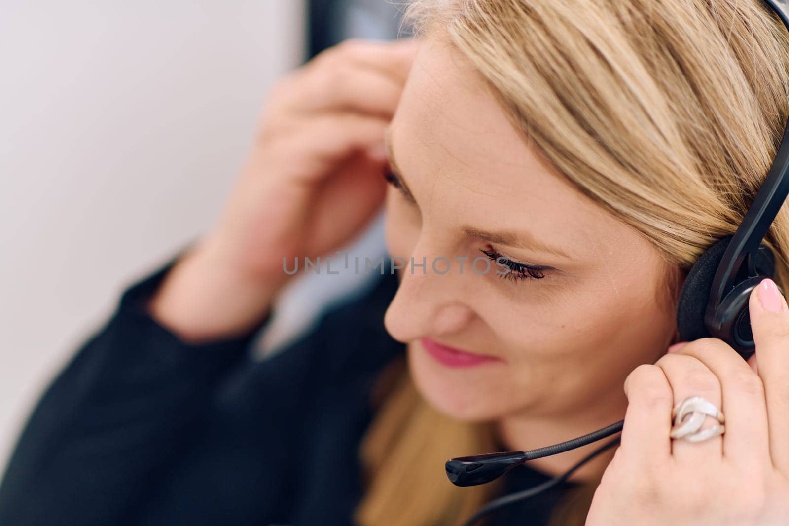 Friendly call center agent answering incoming calls with a headset, providing customer service remotely. Happy woman using her excellent communication skills to resolves customer issues.