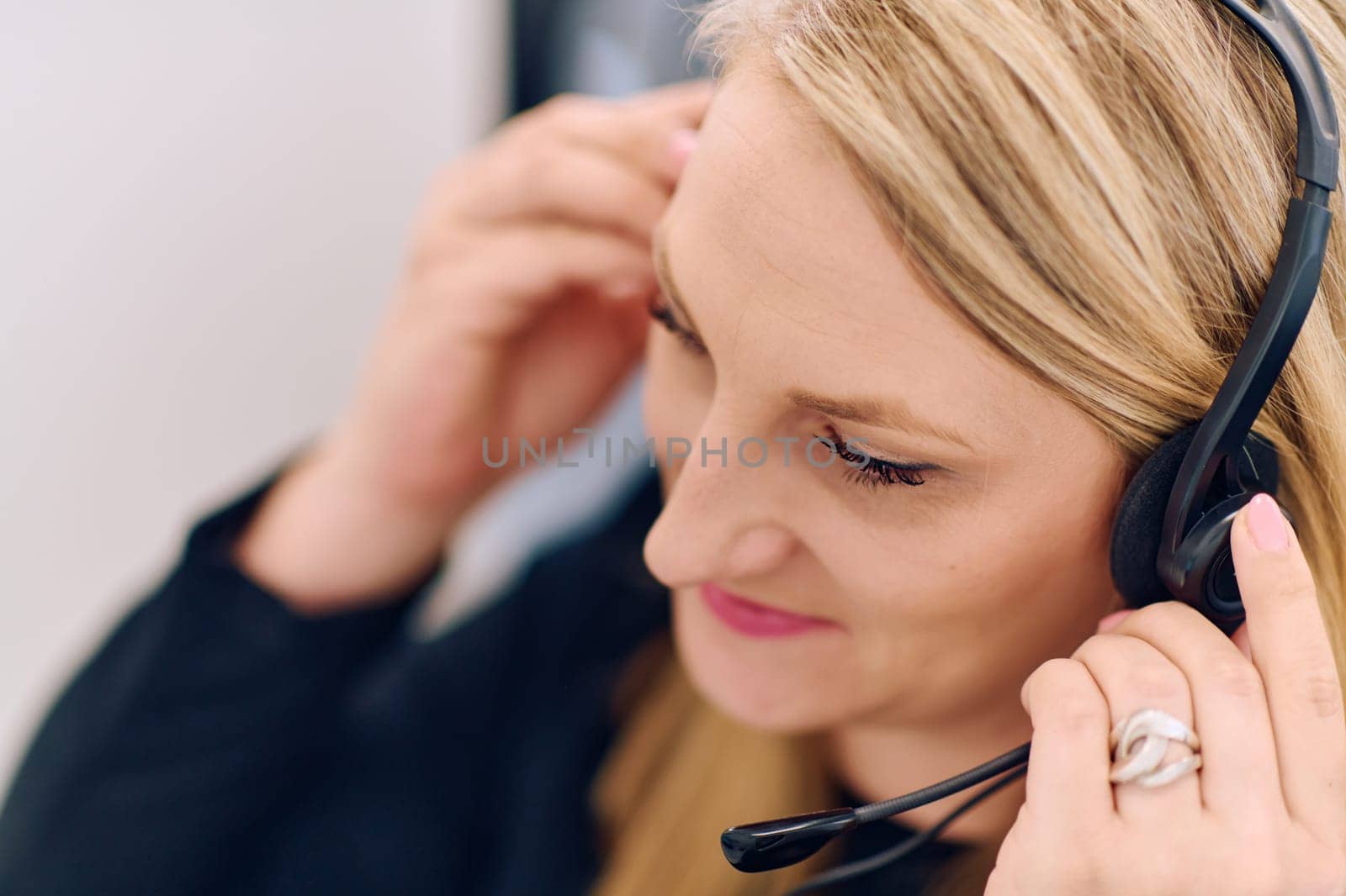 Friendly call center agent answering incoming calls with a headset, providing customer service remotely. Happy woman using her excellent communication skills to resolves customer issues.