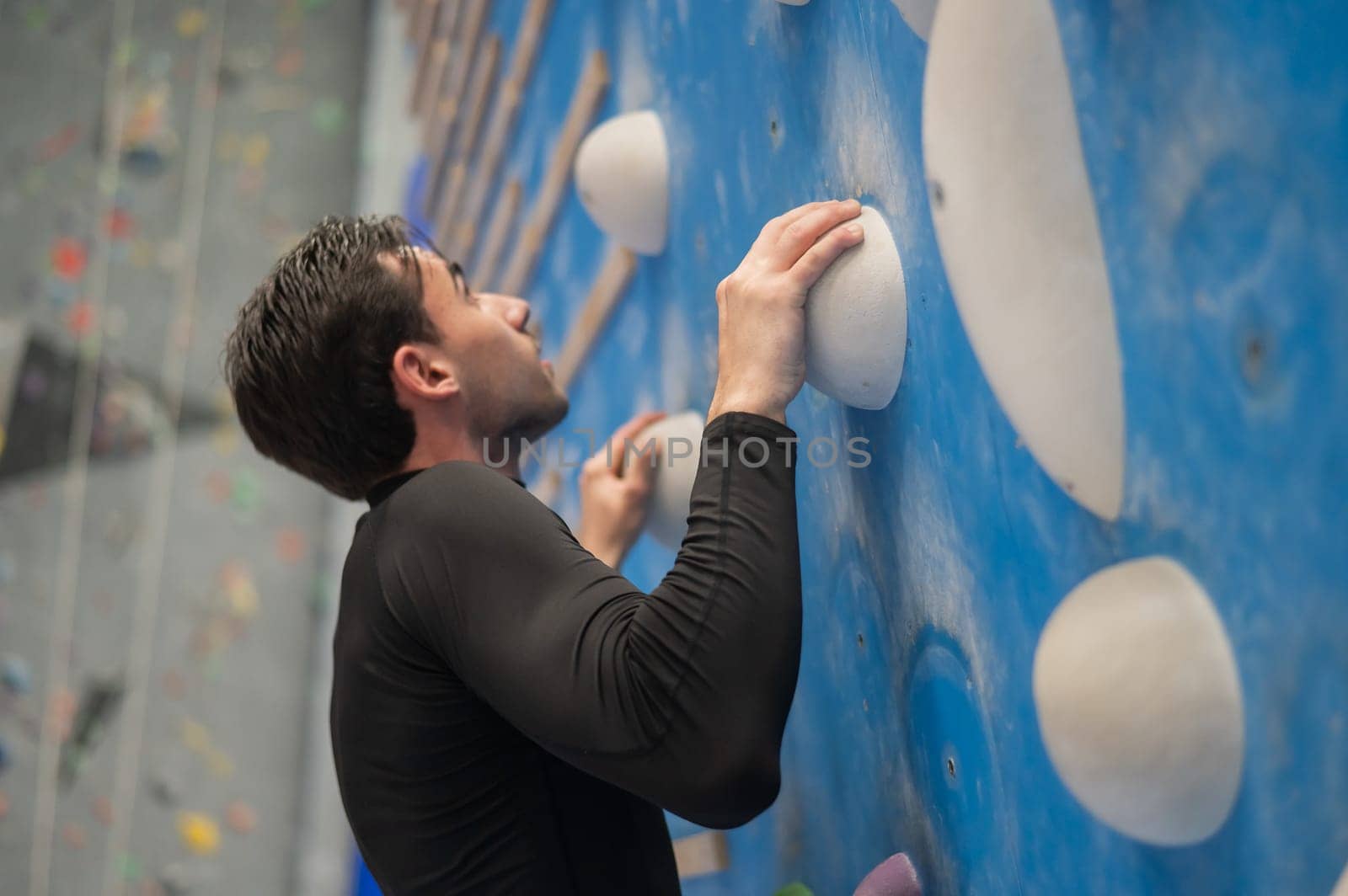 Caucasian man training on a climbing wall. by mrwed54