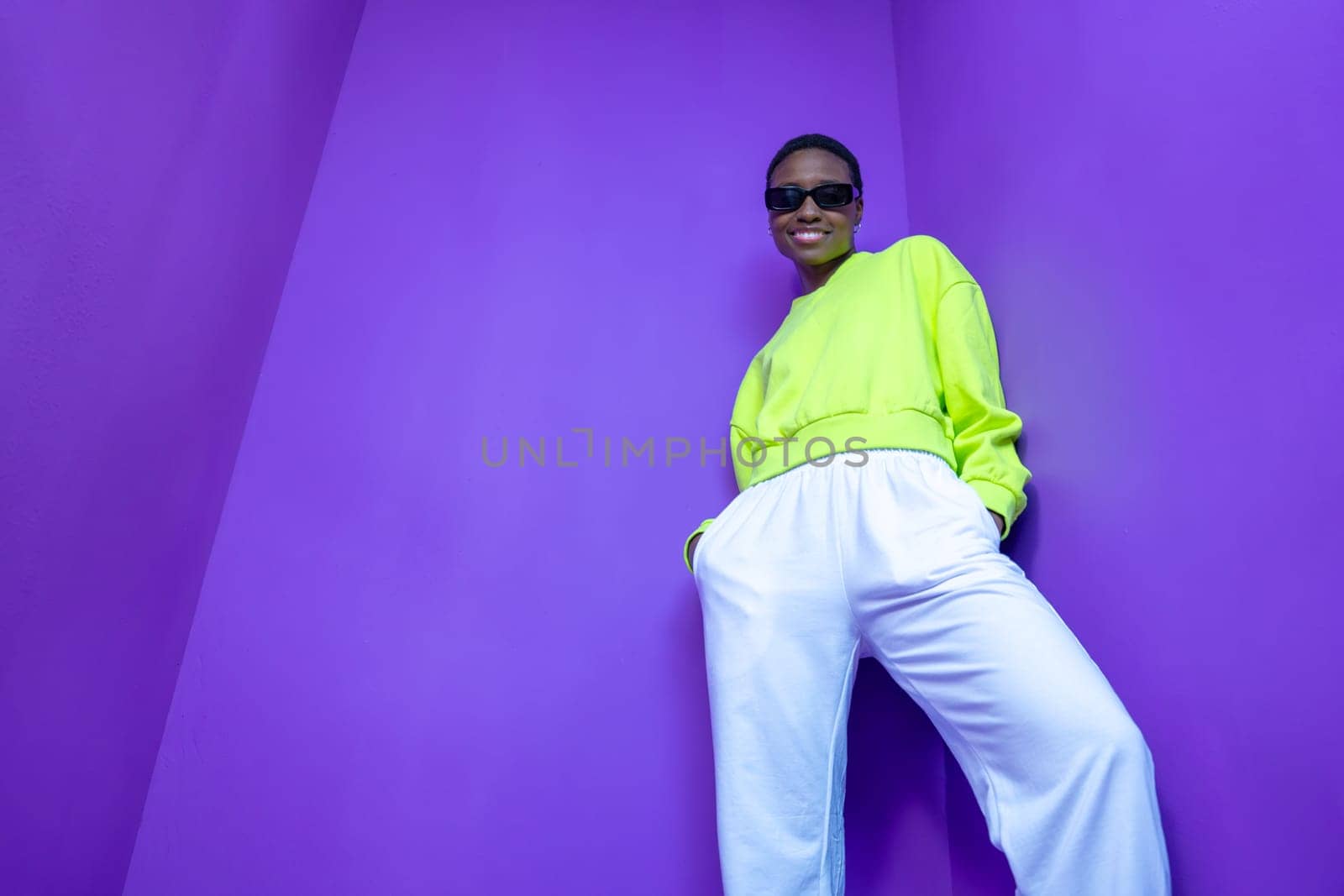 Cheerful black lady pose isolated over violet background by PaulCarr