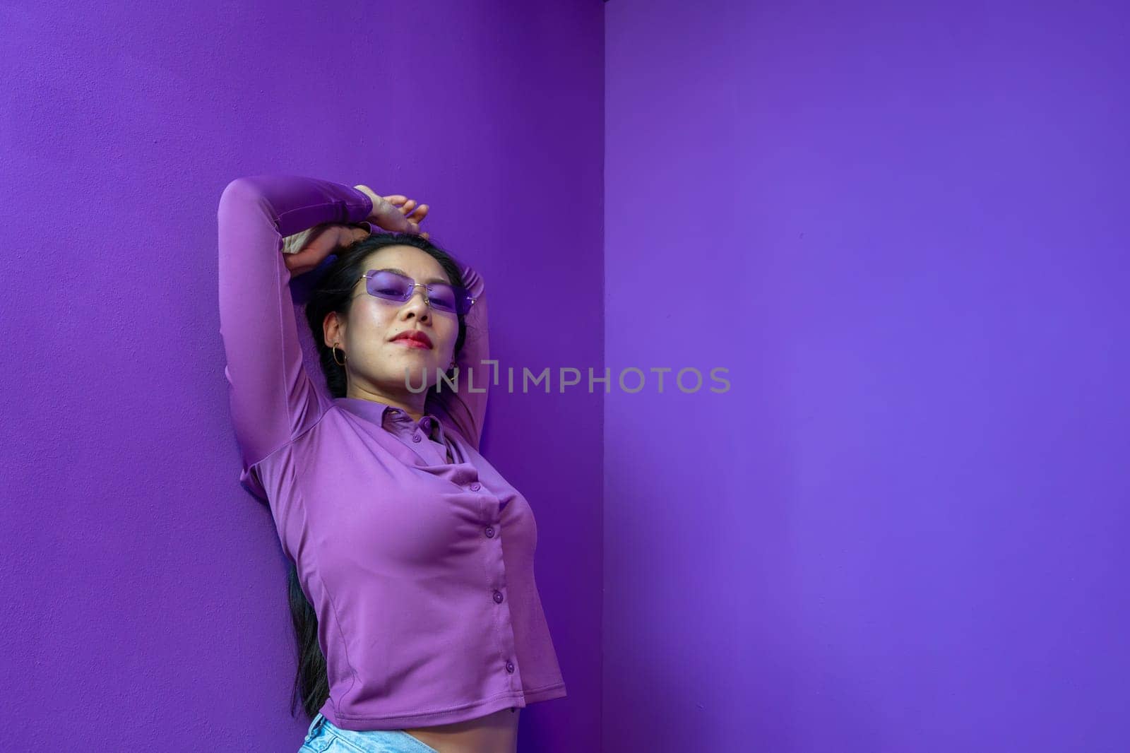 Elegant beautiful Asian woman on colorful bright violet background posing. High quality photo