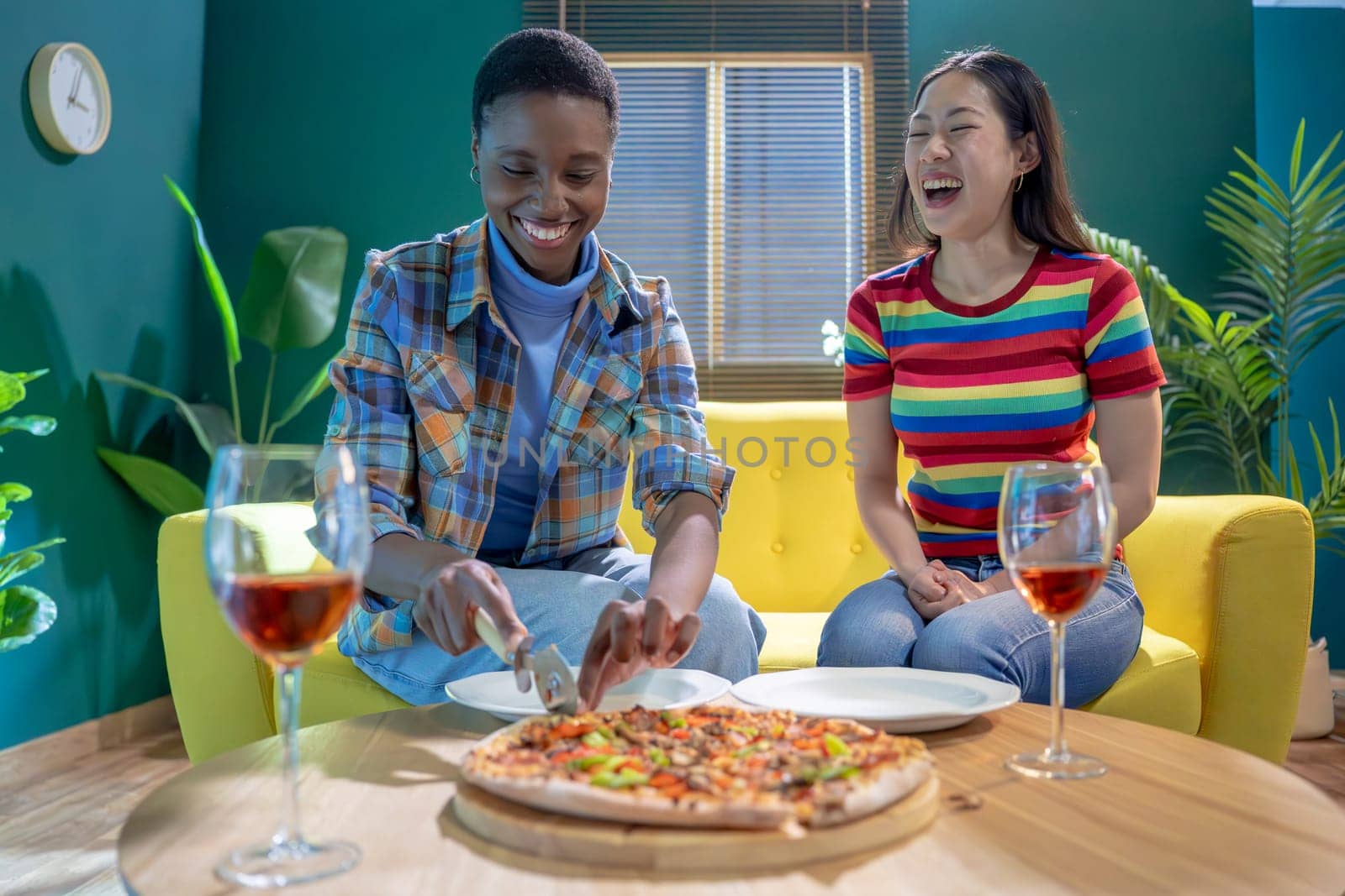 Two female friends celebrating with pizza and wine. by PaulCarr