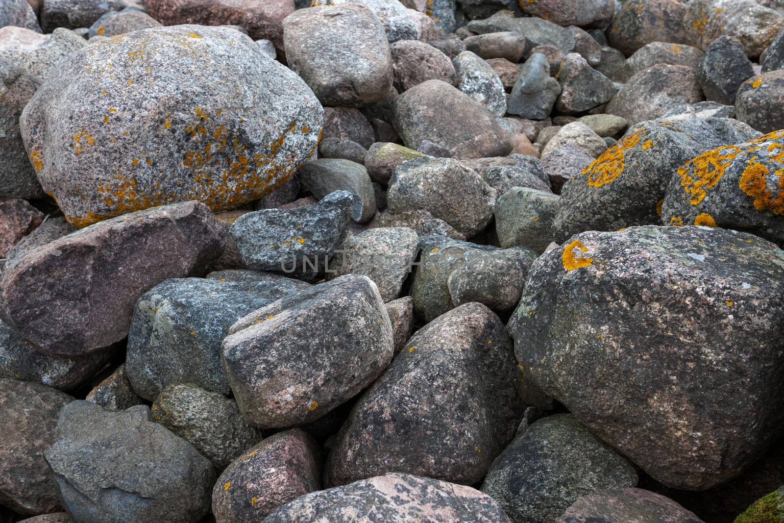Huge boulders scattered randomly on the site of an old stone pier. Stones background and texture. Ainazi North Pier