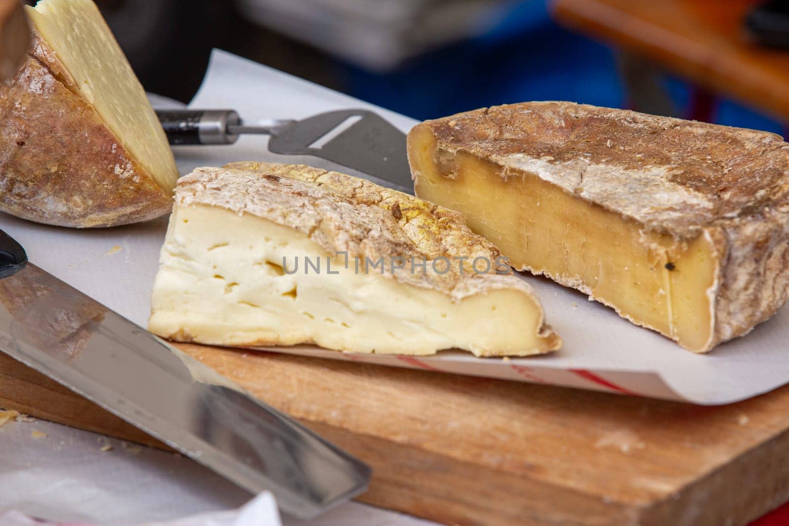 Rustic artisan cheeses on a wooden cutting board, showcasing various textures and natural rinds