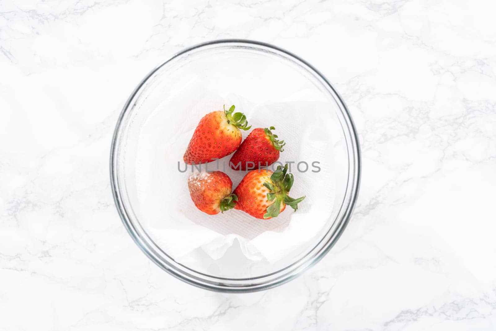 Fresh and Moldy Strawberries in a Glass Bowl on a White Napkin by arinahabich