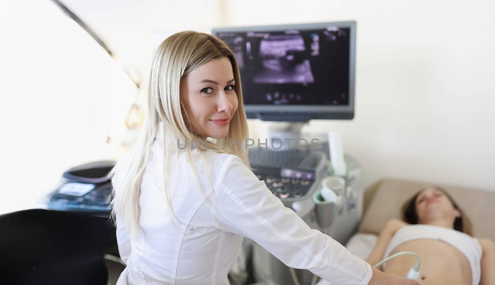 Doctor doing ultrasound scan to woman patient in clinic. Instrumental diagnostics concept