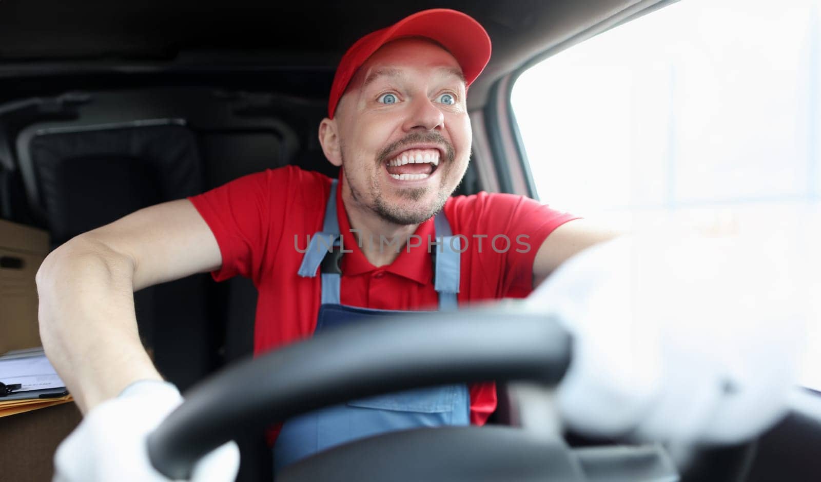 Happy young male courier driving fast car. Quality delivery concept