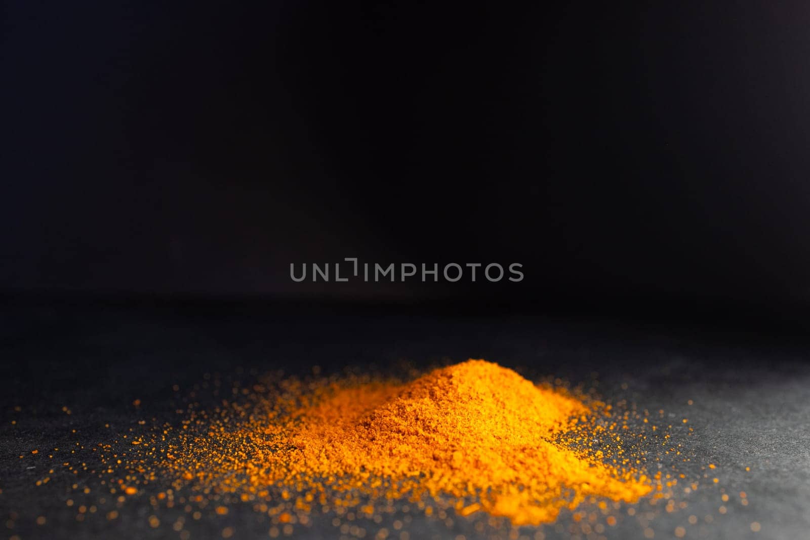 Horizontal picture of pile ofparika on a rustic black table.Dark background. by VeroDibe