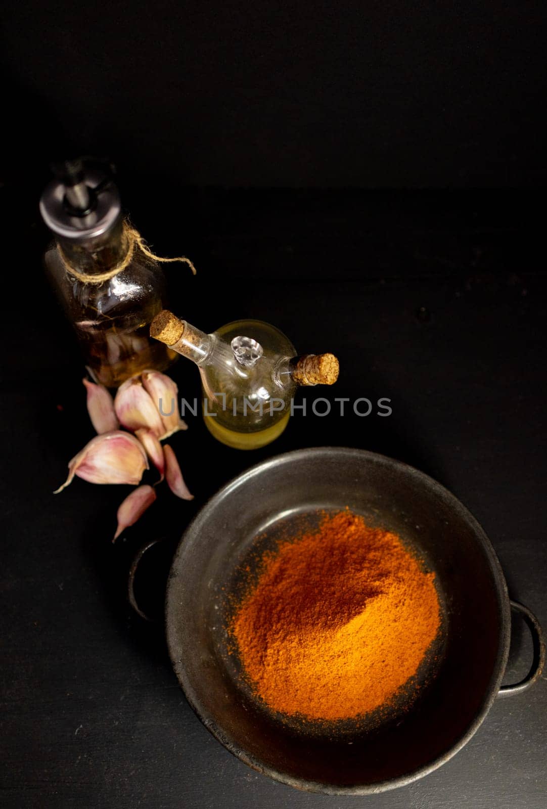 Overhead image of condiments and ingredients on black table. by VeroDibe