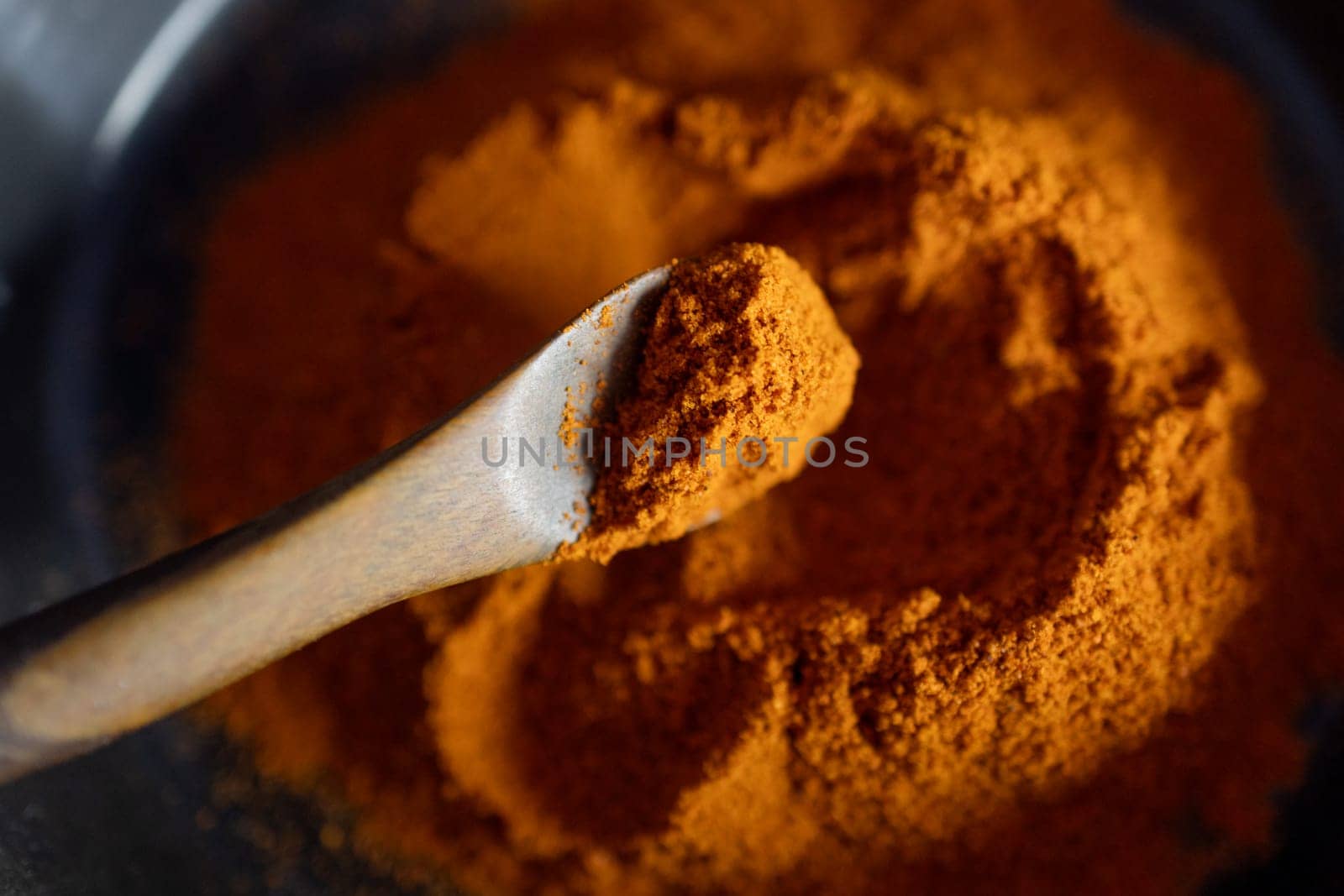 Macro, top view of red paprika on a wooden spoon. by VeroDibe