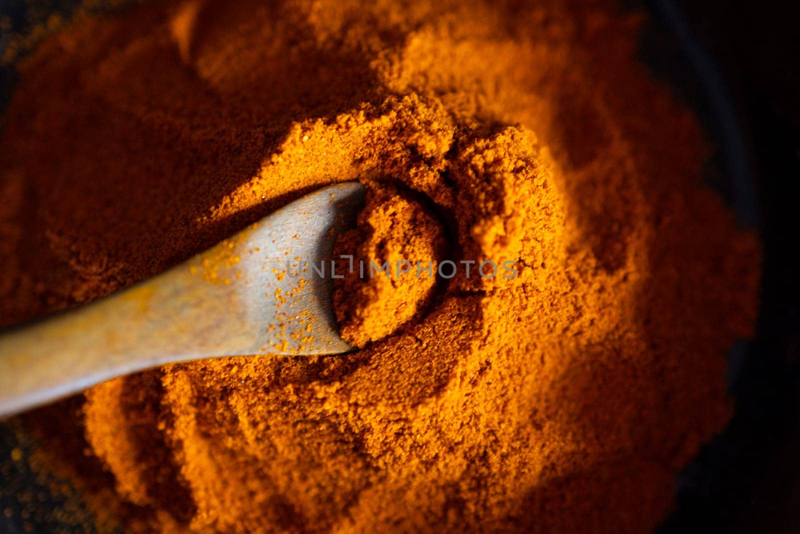 Very close up view of Paprika on a wooden spoon.Side light. by VeroDibe