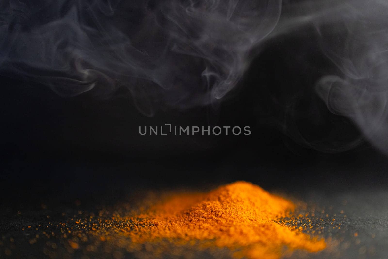 Side view of pile of red parika with smoke around it. Dark background by VeroDibe