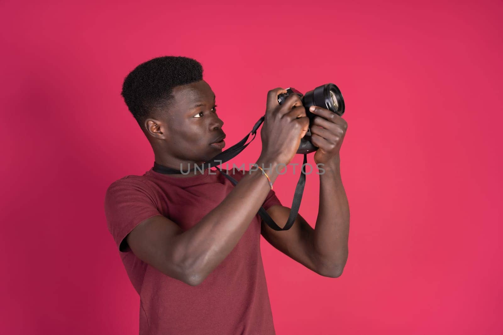 A man in a red shirt is taking a picture with a camera by Ceballos