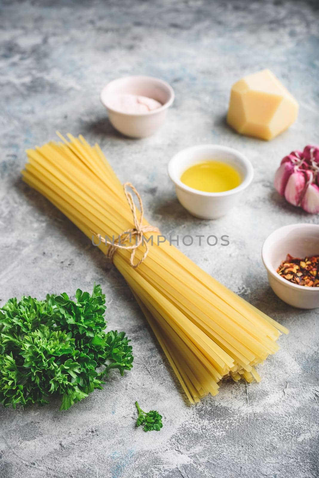 Raw ingredients for cooking linguine with olive oil, garlic and parsley