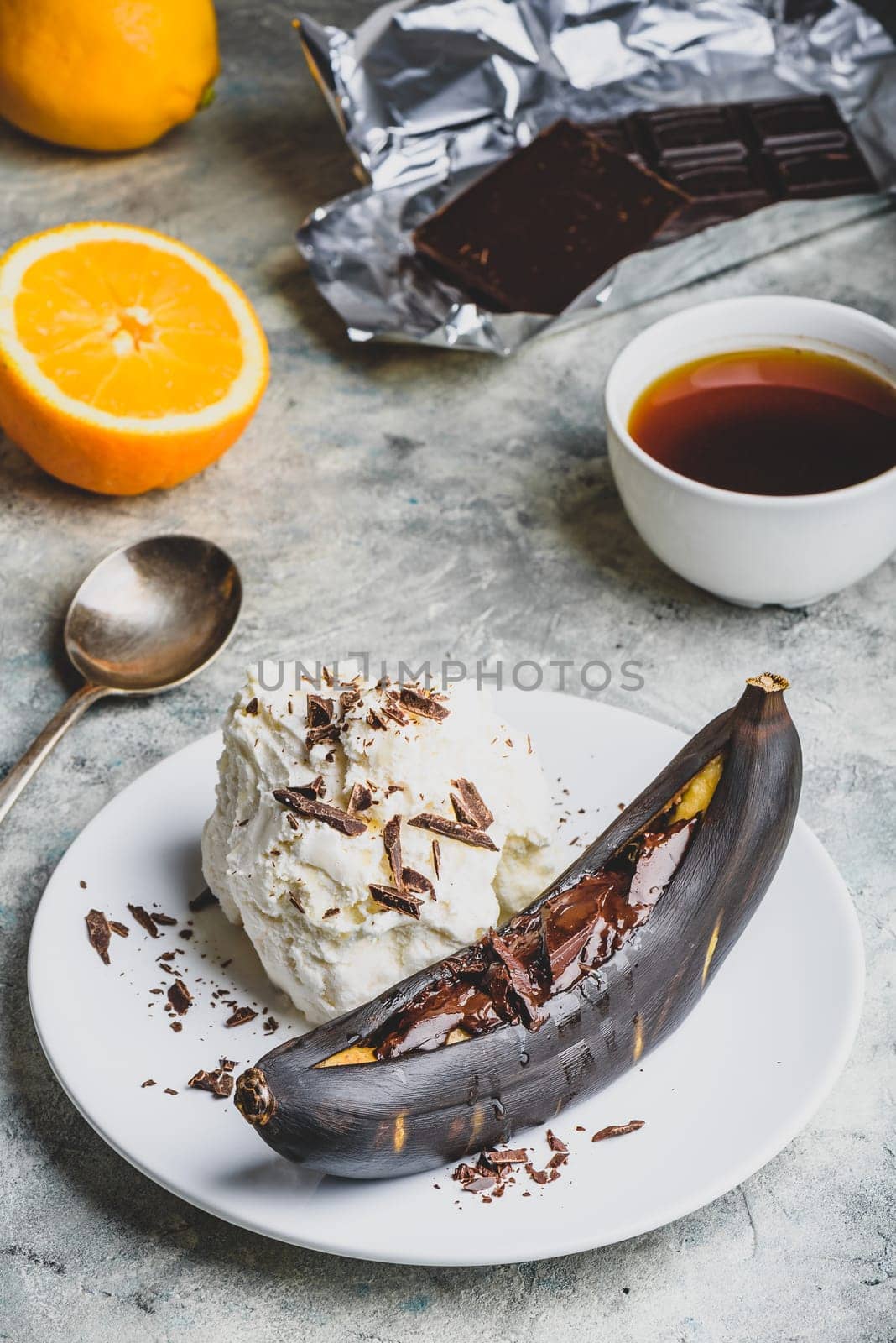 Sweet dessert. Grilled banana with dark chocolate, citrus juice and vanilla ice cream.