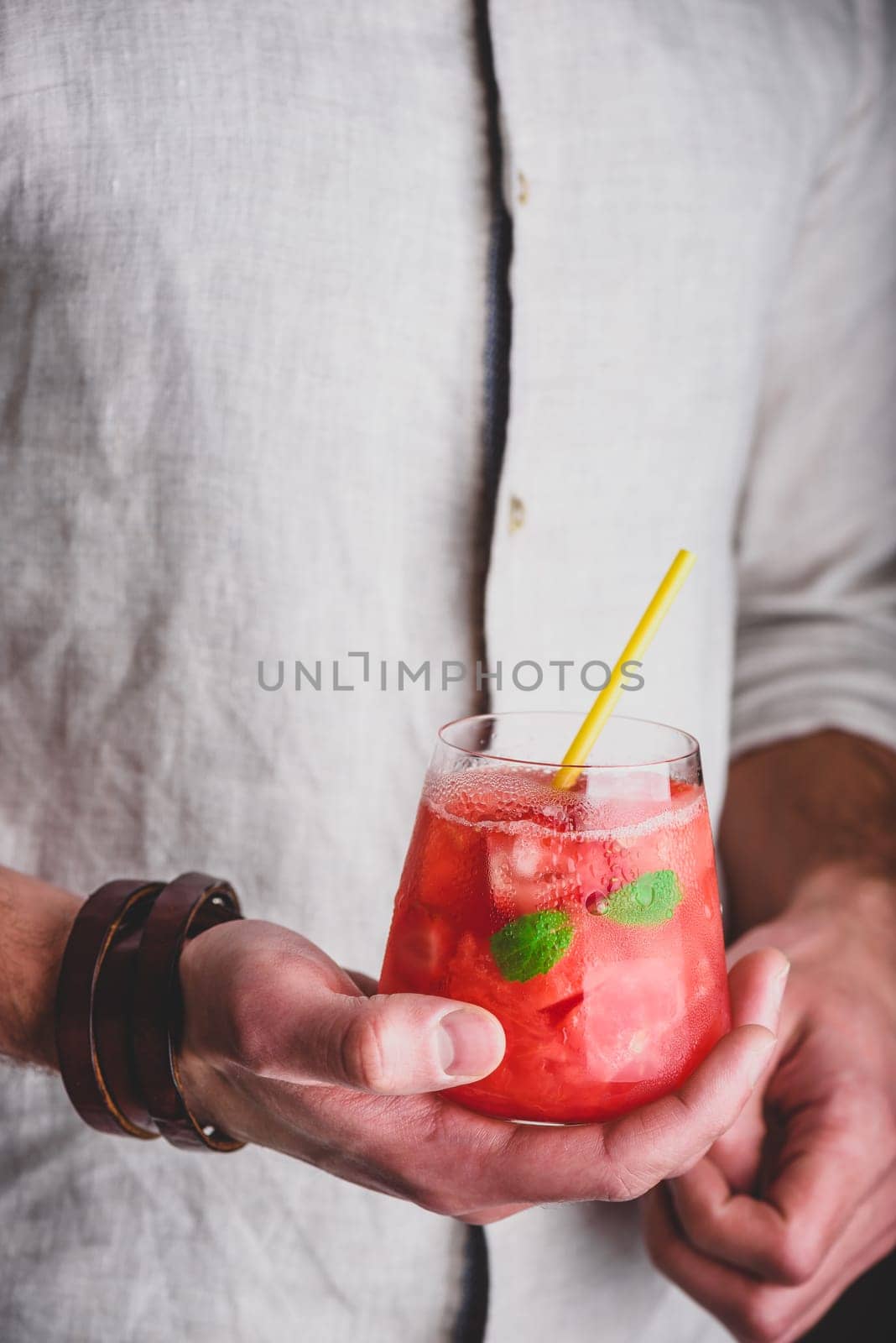 Glass of watermelon and gin cocktail in hands by Seva_blsv