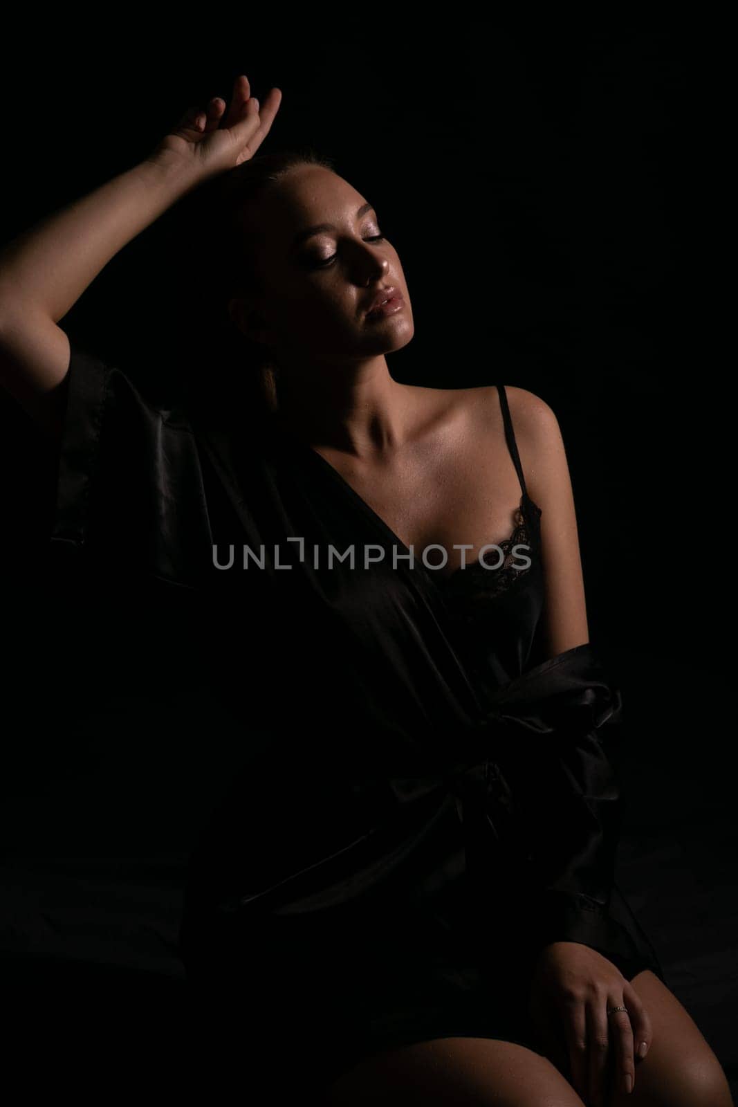 woman in black nightwear poses in the shadow of a room