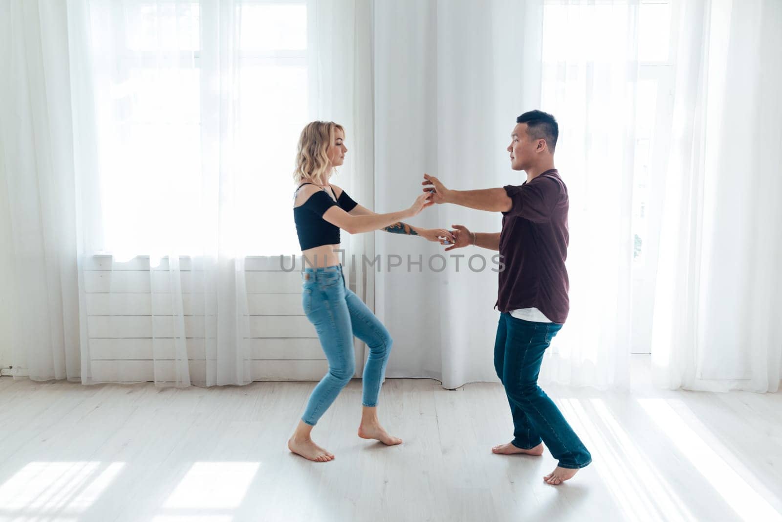 a man and woman dance in the hall of the latin bachata studio