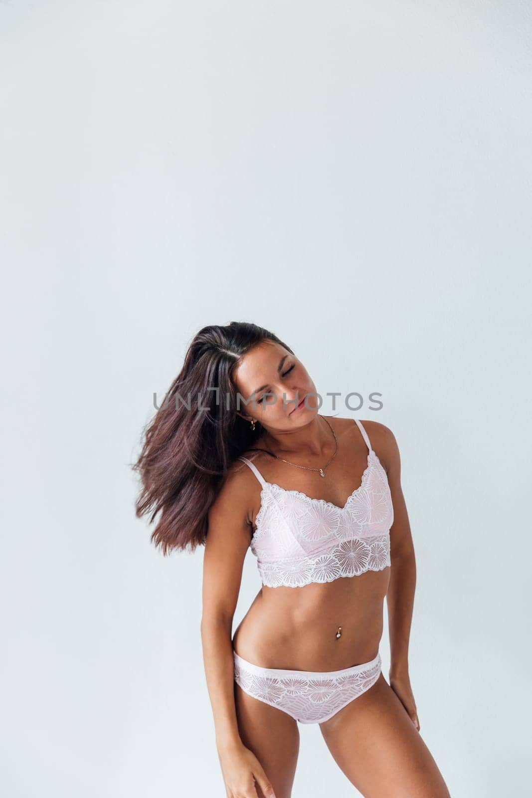 woman in white underwear stands in a bright room