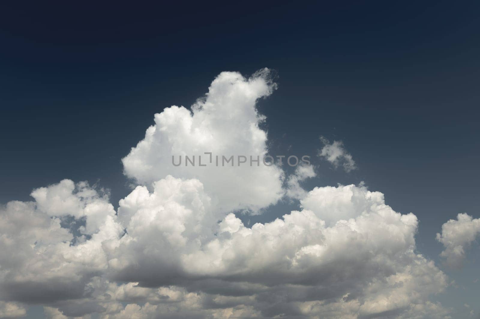 The natural blue sky has clouds. sky background on dark dramatic blue on a sunny day