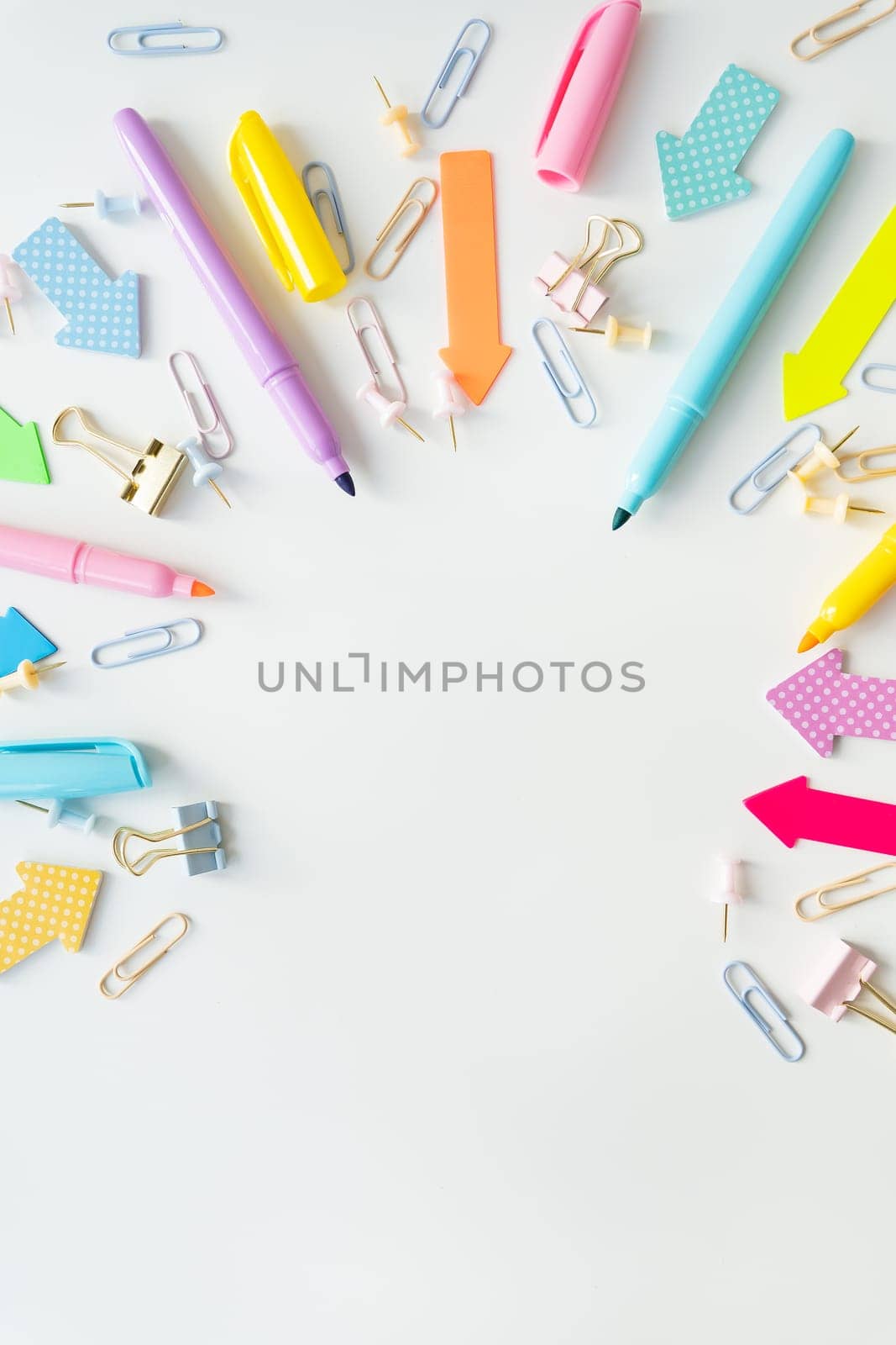 Top view of bright school supplies with blank paper for layout or text. Vertical photo. by sfinks