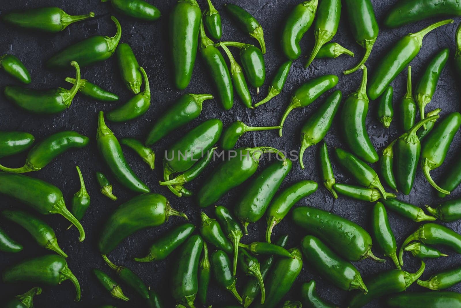 Top View of Green Jalapeno Peppers on Black Concrete Background