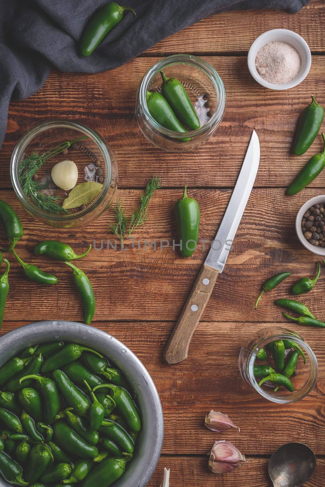 Jalapeno Peppers for Pickling with Peppercorns, Dill and Garlic in Glass Jars on Wooden Table. View from Above