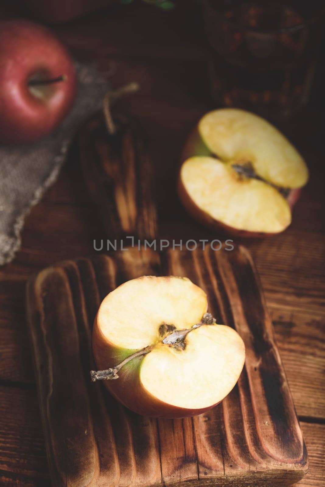 Halved Red Apple on Cutting Board in Rustic Setting by Seva_blsv