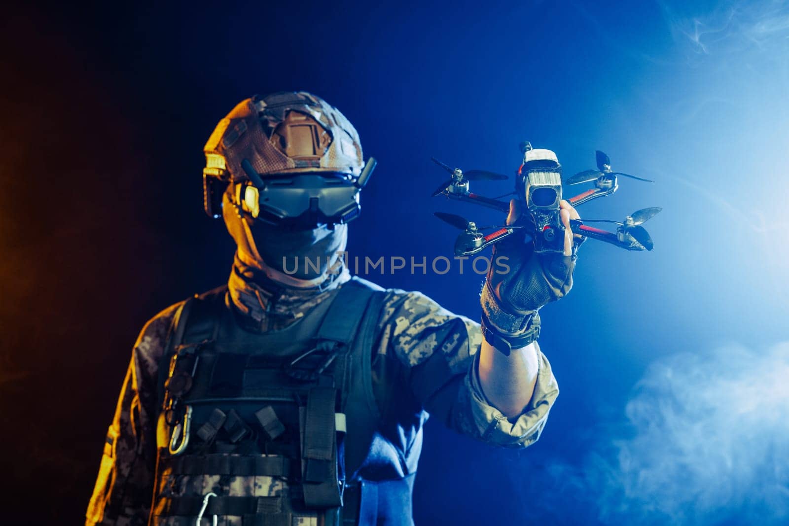 Soldier in gear holds drone against a red and blue smoky background, conveying intensity and military action