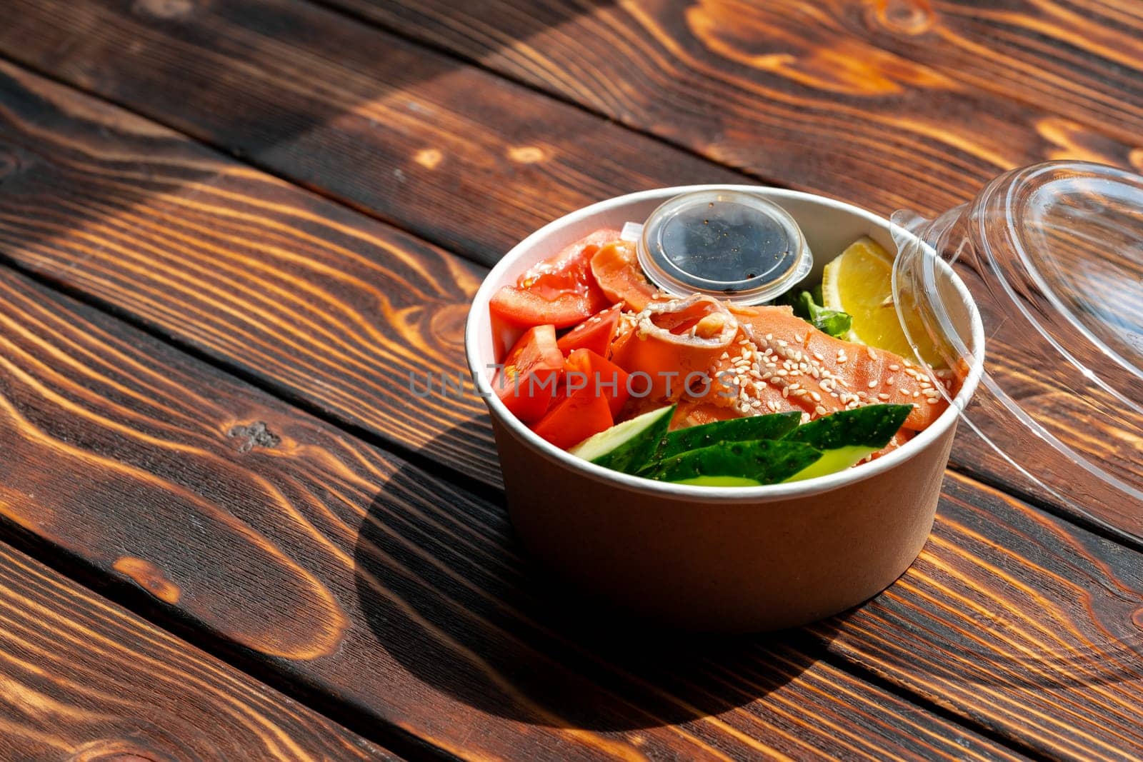 Poke bowl with salmon on wooden background close up