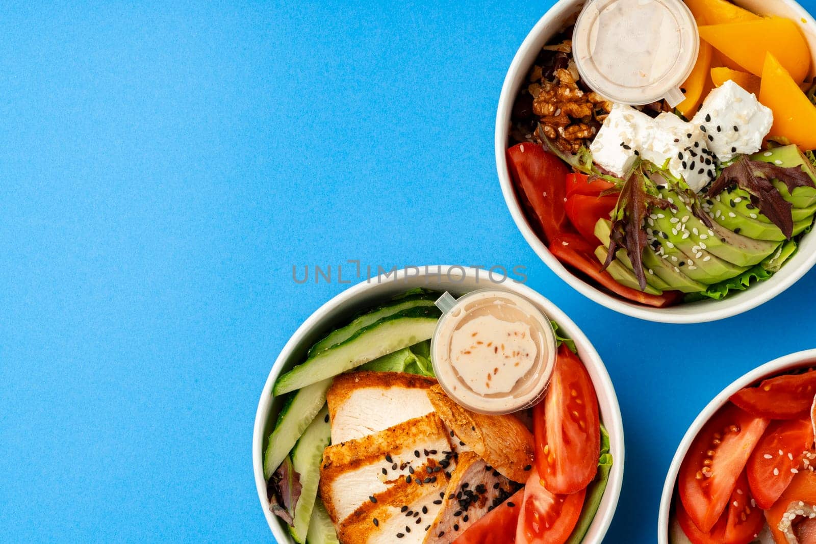 Different poke bowls on blue background top view photo