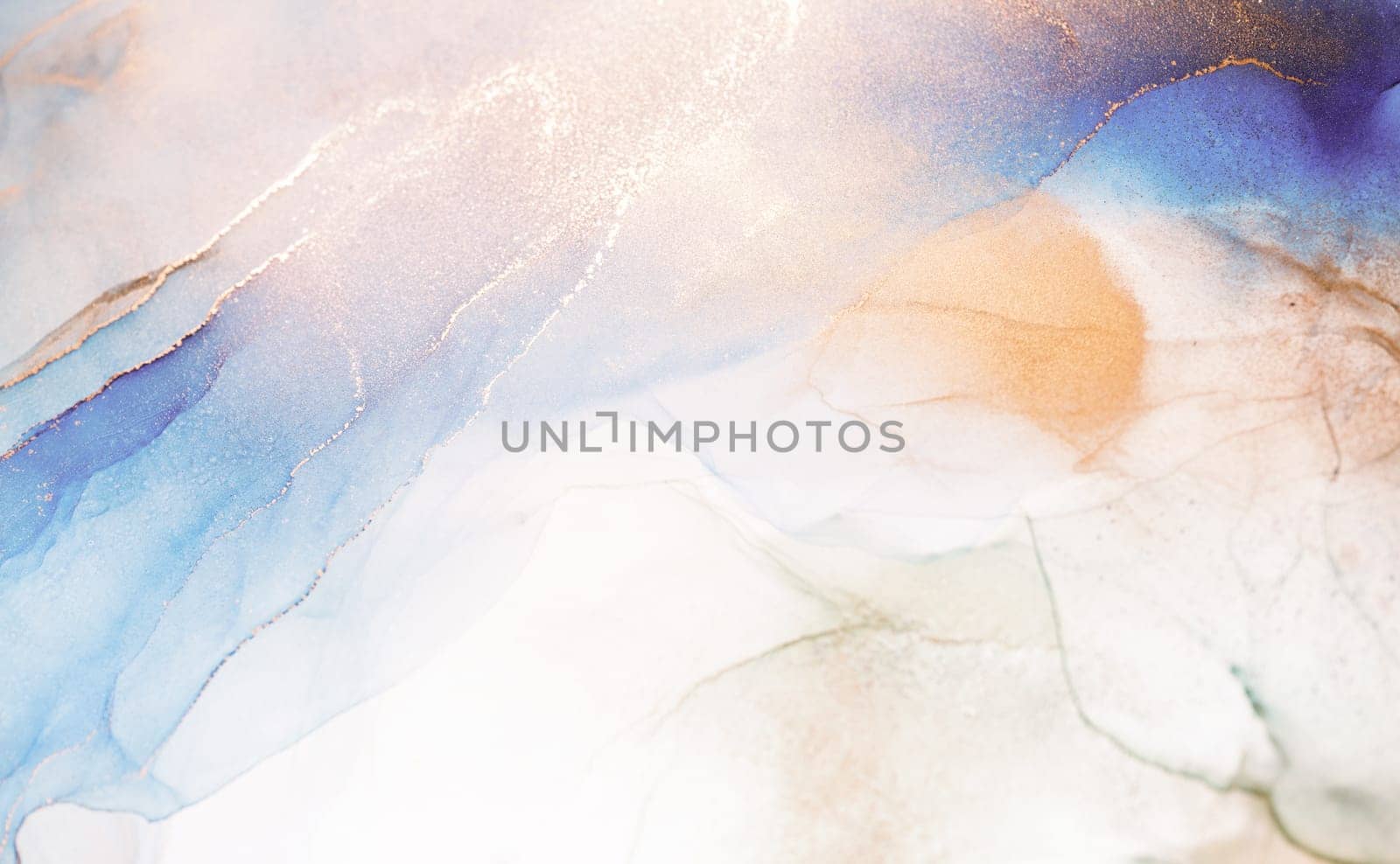 A close-up shot of abstract ink swirls in blue, gold, and peach colors. The colors blend and create a dynamic and ethereal effect.