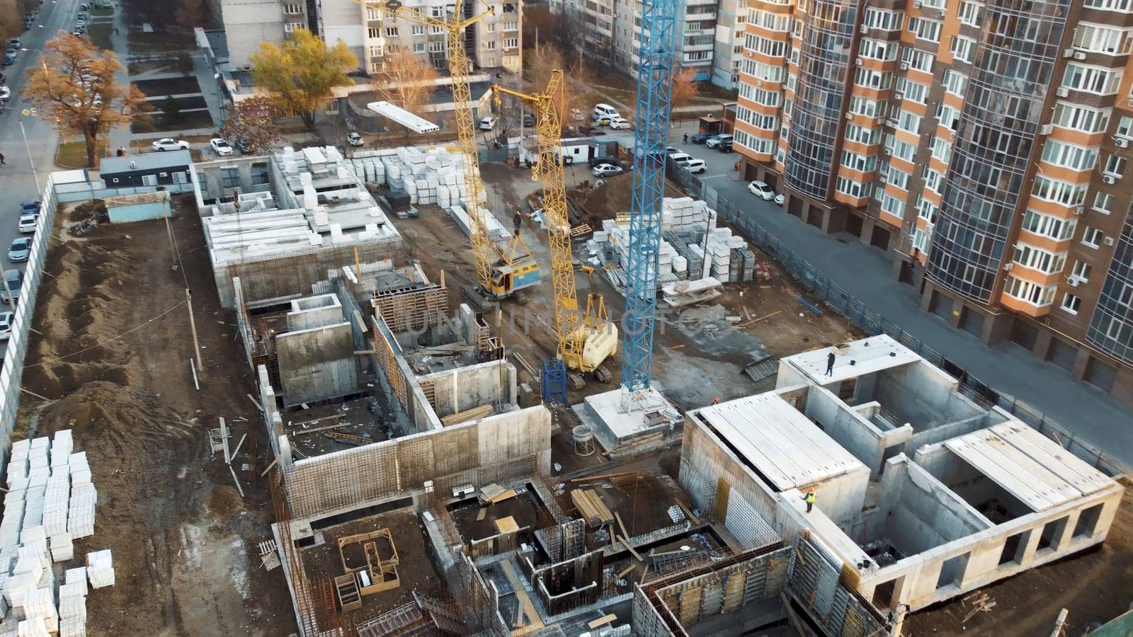 The surrounding area is a mix of completed high-rise buildings and vacant lots.