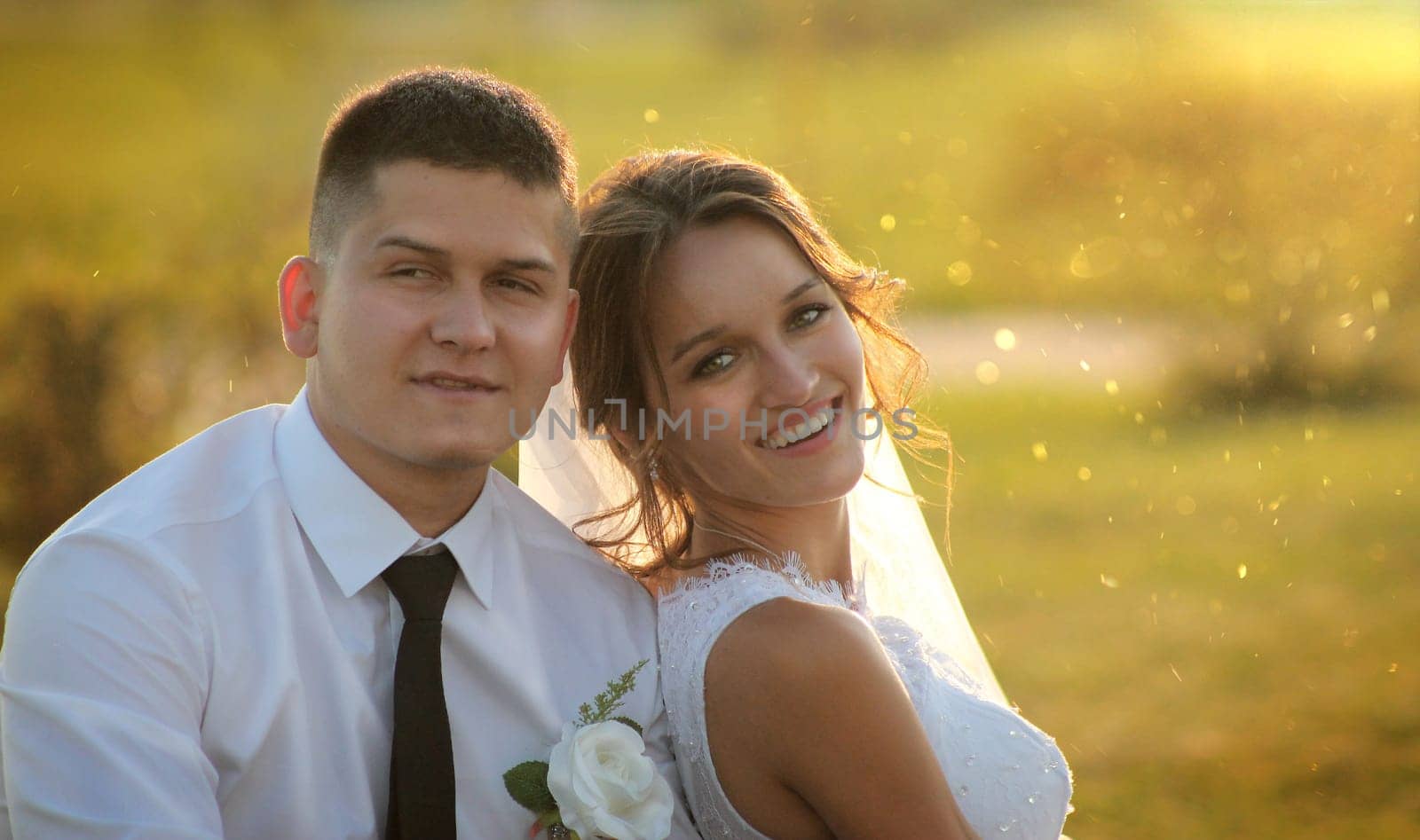 Portrait of a happy bride and groom in the rays of the setting sun. High quality photo