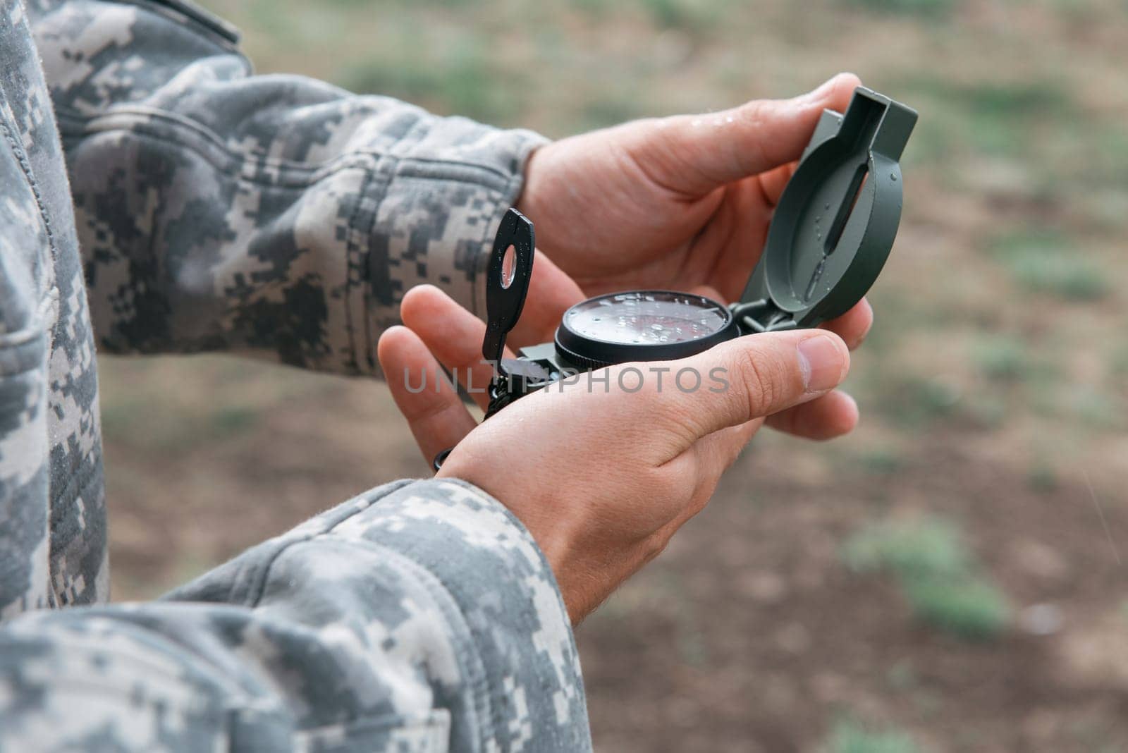 Man with compass in hand outdoor. Travel concept.