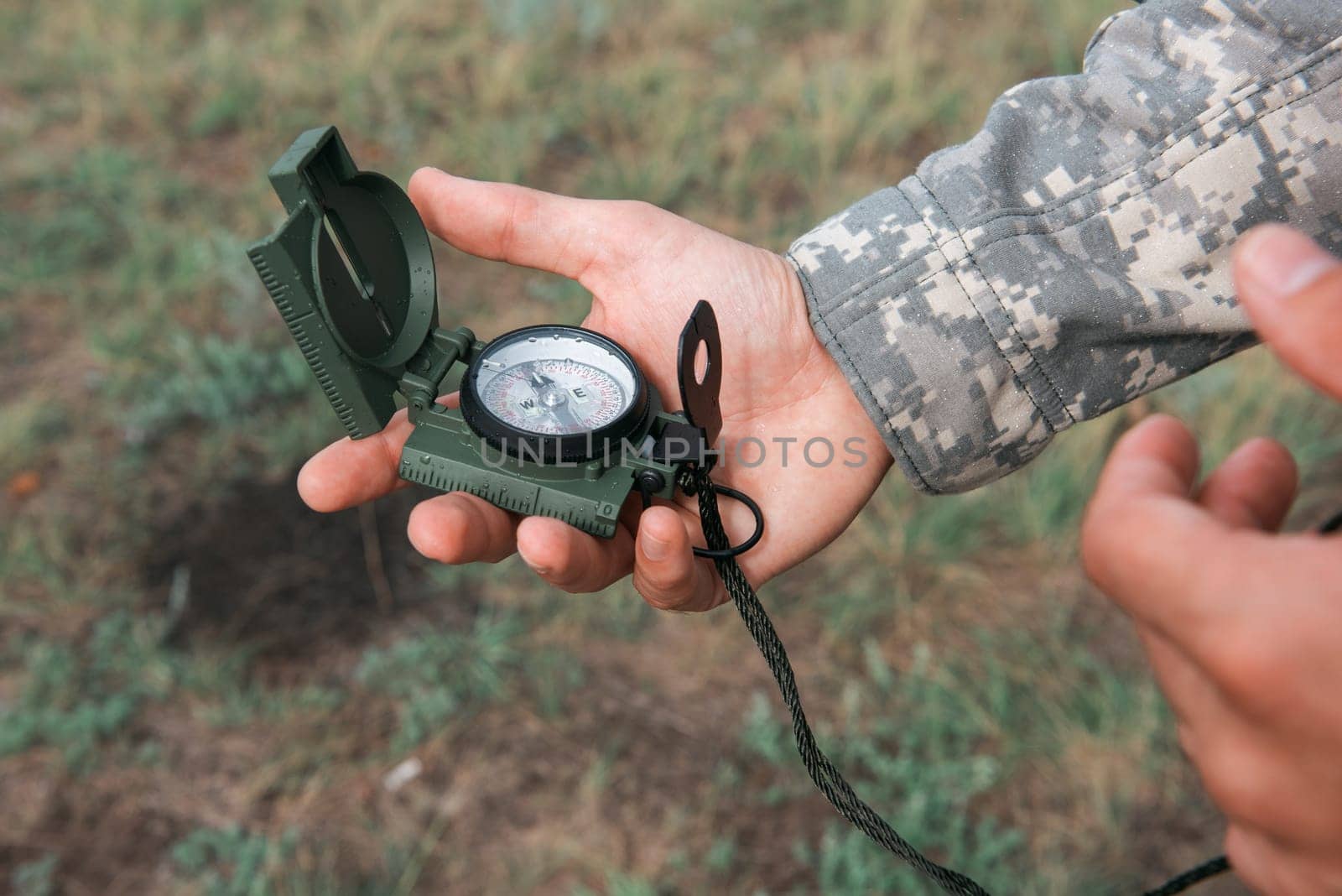 Man with compass in hand outdoor. Travel concept.