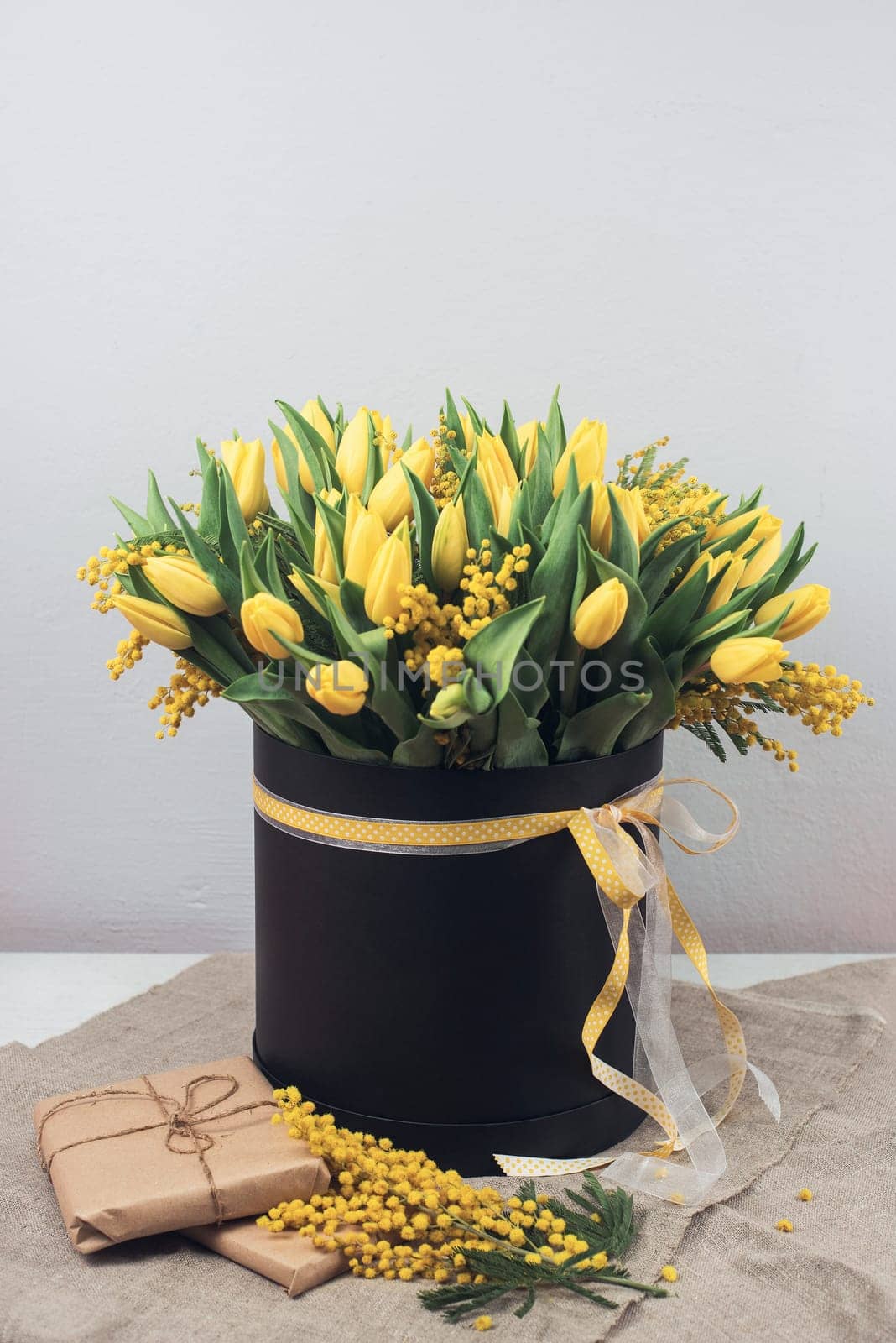 Bright spring bouquet of tulips and mimosa flowers. Mother's Day or Easter theme.