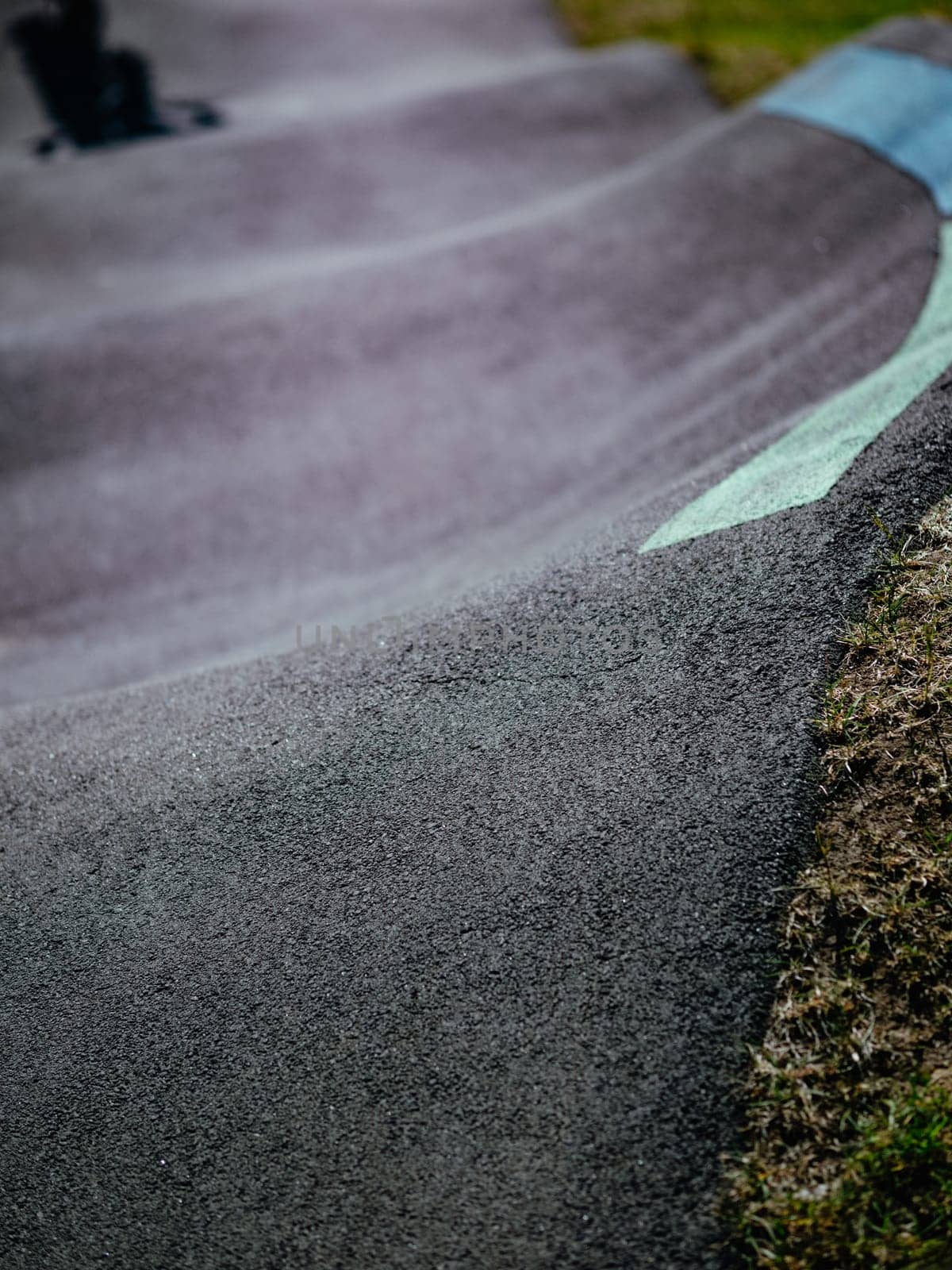 Pump track close up. Pumptrack curves with lines. Asphalted bicycle race track, pump track outdoors, kids playground. Racing speed track