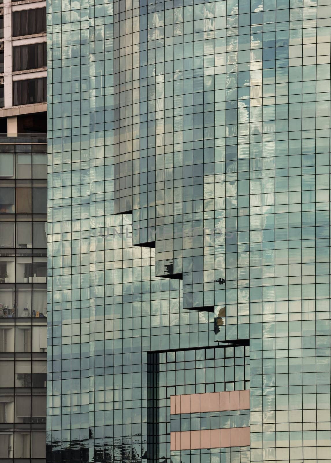 Bangkok, Thailand - 22 Jun, 2024 - Architectural exterior of modern office building facade with sky and clouds reflection in windows. Steel frame and glass windows architecture, Space for text, Selective focus.