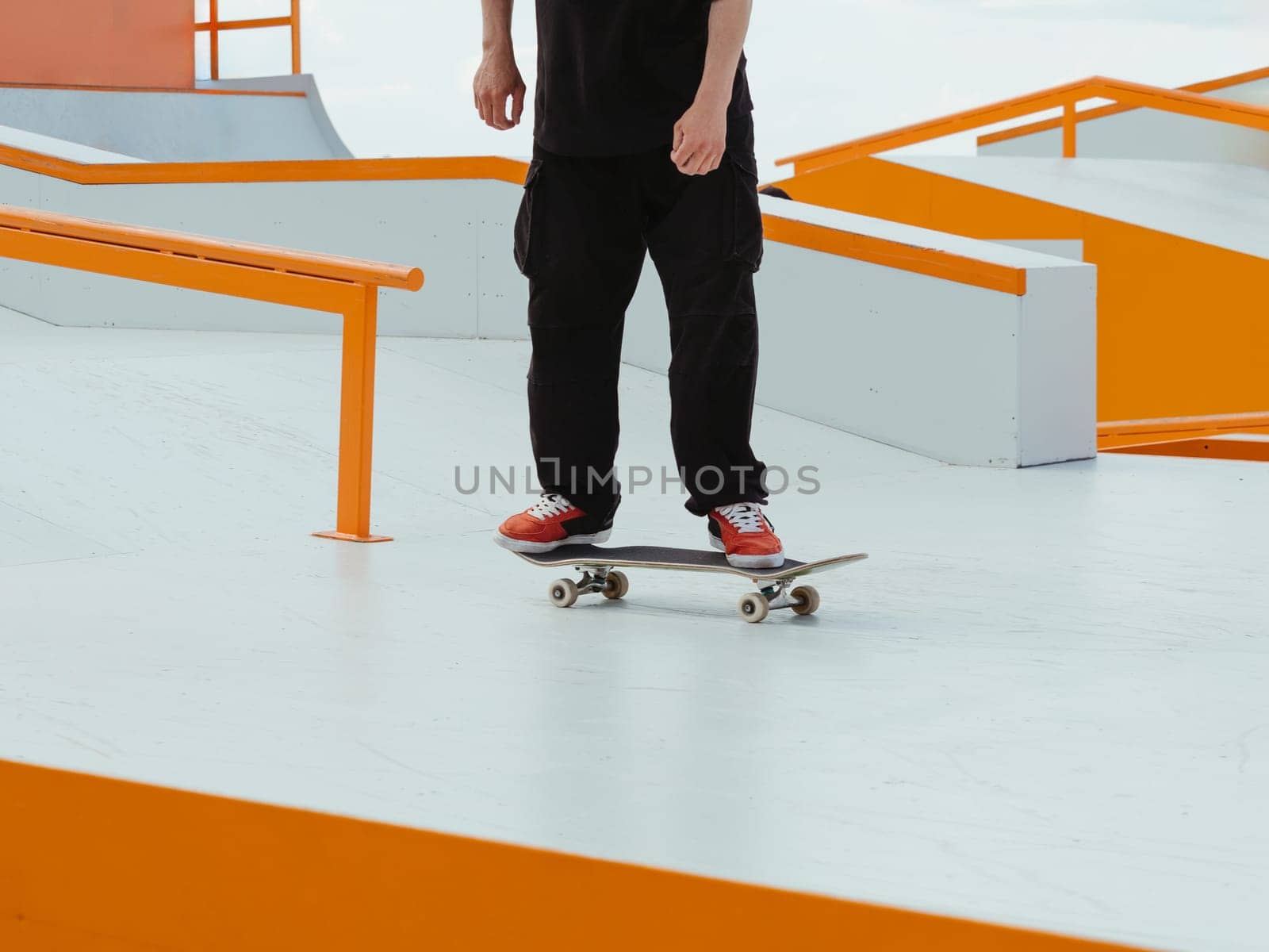 Skateboard Skater Skating in Skate Park Outdoor. Professional skater athlete in black jeans rides a skateboard