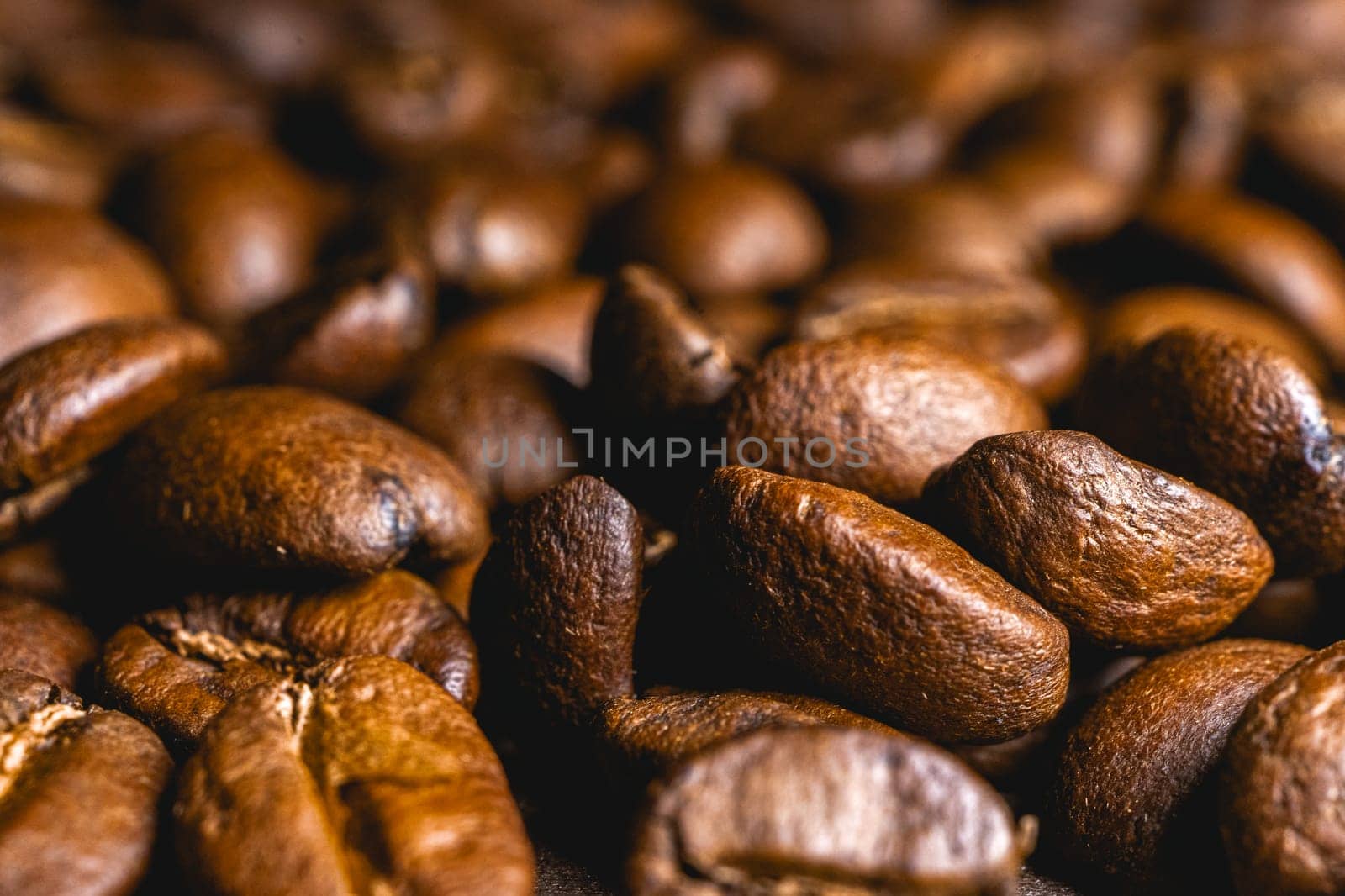 Close up from a bunch of coffee beans laying down. Backdrop for coffee products.