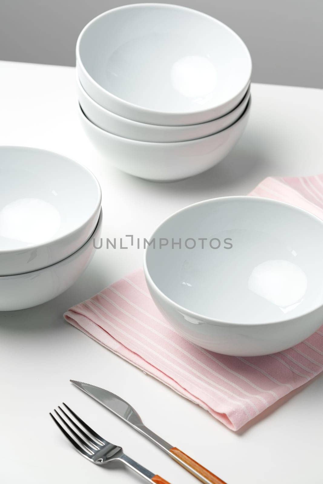 Stylish table setting with white dishware on white tablecloth close up