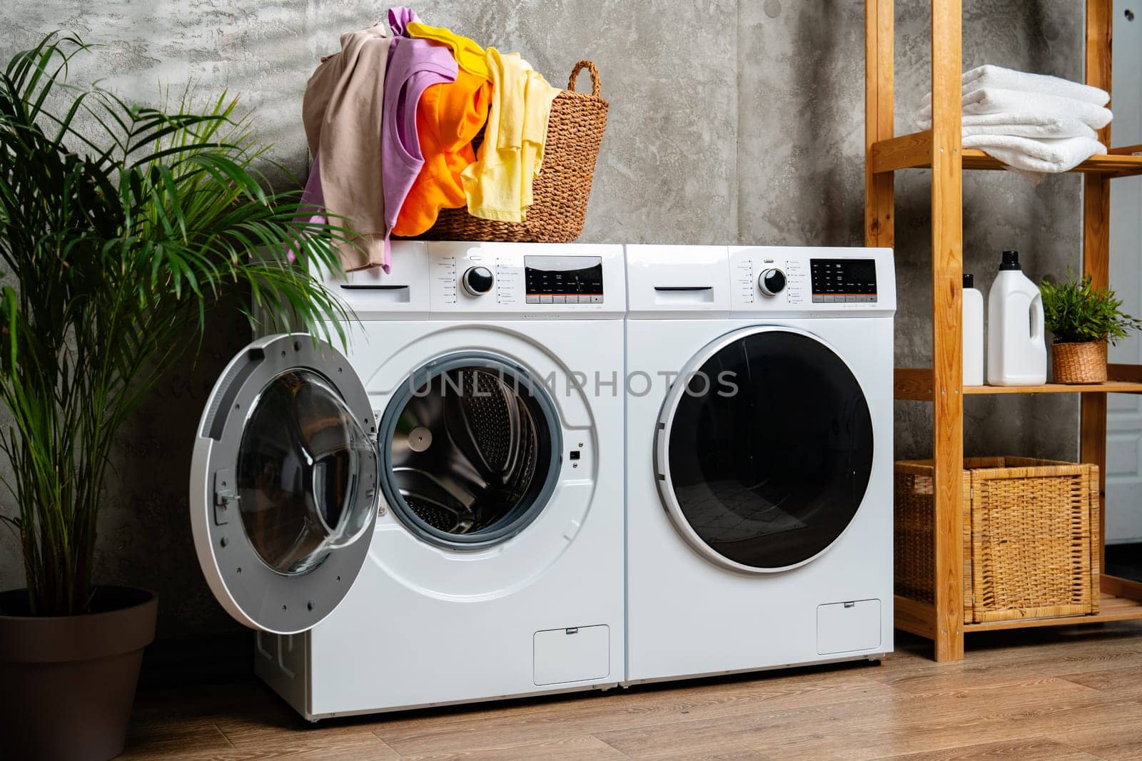 A photo of two modern white washing machines in a laundry room.